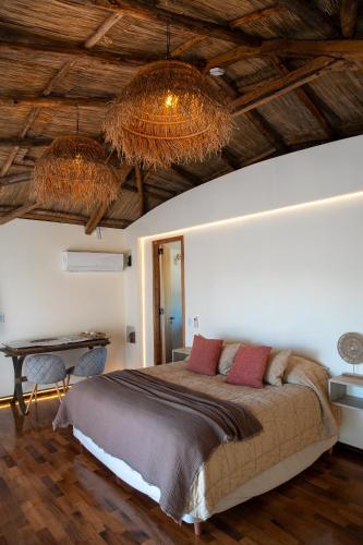 a bedroom with a large bed and two chandeliers at Bali Andino Vilas in Ciudad Lujan de Cuyo