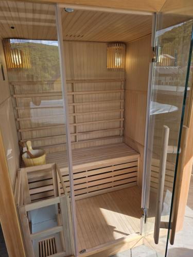 a sauna with a glass door and a stool at Pensiunea Maya Caciulata in Caciulata