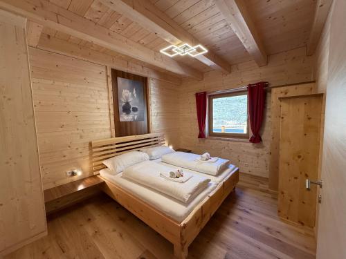 a bedroom with a bed in a wooden room at Wellness Chalet Zirbitz in Lavantegg