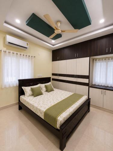 a bedroom with a bed with a ceiling fan at Gachi Ghar Gachibowli 2 BHK in Hyderabad