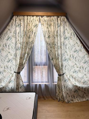 a room with a window with curtains and a mattress at Narnia Cottages in Bazalet'i
