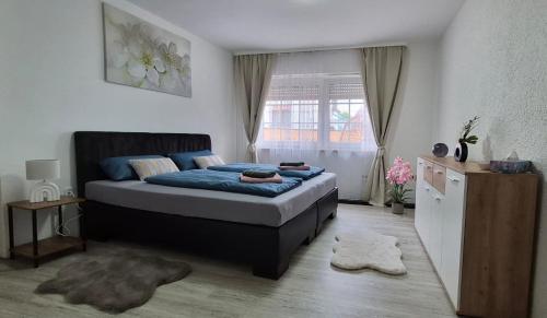 a bedroom with a bed with blue sheets and a window at Ferienwohnung Alex in Nidderau