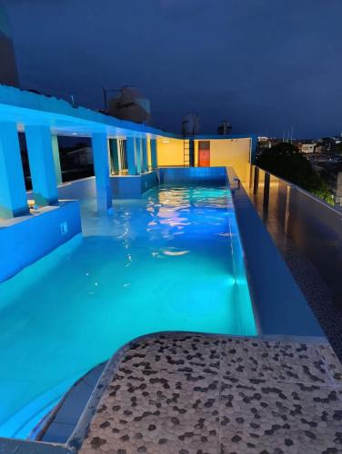 a swimming pool on the roof of a building at night at California Bambú in Iquitos