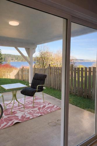 a screened in porch with a table and a chair at Lagoon Views Near Bird Sanctuary in Victoria
