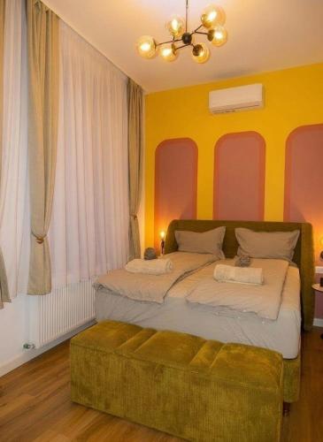 a bedroom with a large bed with yellow walls at Central Residence Aiud in Aiud