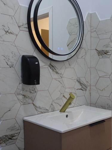 a bathroom with a sink and a mirror at Central Residence Aiud in Aiud