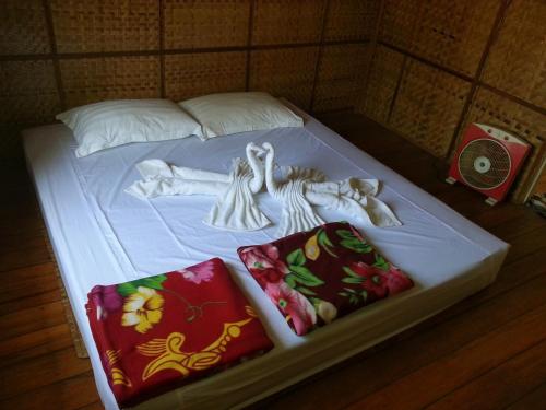 a white bed with dolls on top of it at Soe Ko Ko Beach House & Restaurant in Ngwesaung