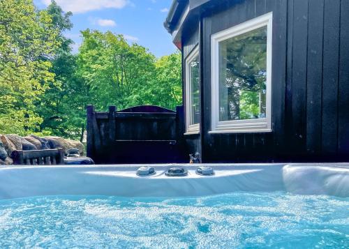 a hot tub in front of a black house at Glen Clova Lodges in Angus