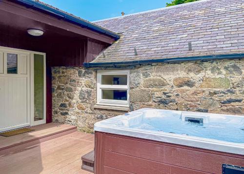 a large hot tub in front of a stone building at Glen Clova Lodges in Angus