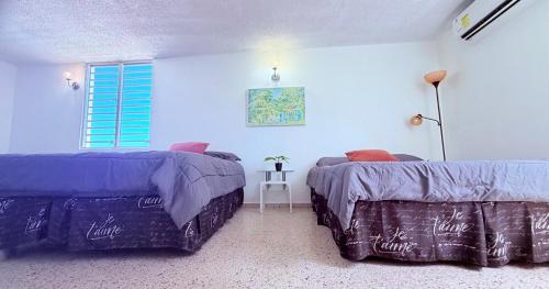 a bedroom with two beds and a table in it at Comfortable Apartment in the Greater Ponce Area in Ponce