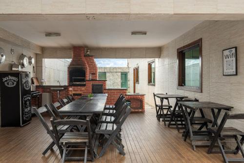 a dining room with tables and chairs and a fireplace at House with Pool in BH for Groups and Families in Belo Horizonte