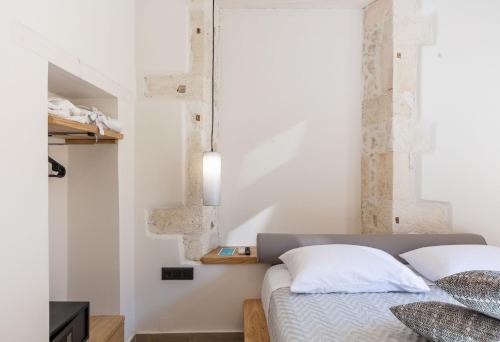 a bedroom with white walls and a bed with white pillows at Margianna's Cupola Luxury Residence in Rethymno