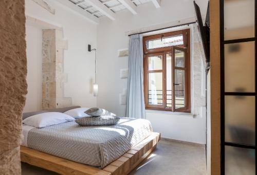 a bedroom with a bed and a window at Margianna's Cupola Luxury Residence in Rethymno