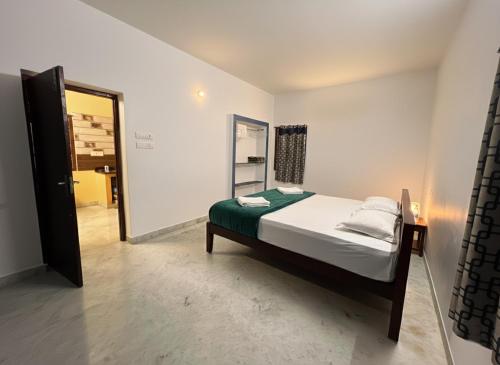 a small bedroom with a bed and a mirror at De Majestic SSK Paradise Beach Villa in Pondicherry