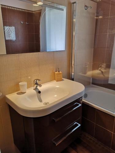 a bathroom with a sink and a mirror and a tub at Altevolte Rooms in Catania