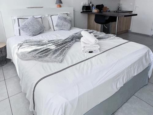 a large bed with white sheets and pillows on it at Domus Via Domitia in Narbonne
