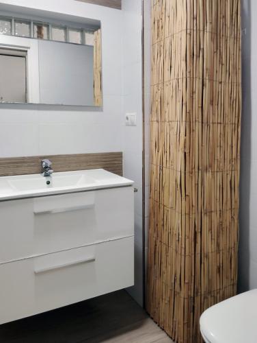 a bathroom with a white sink and a wooden door at Hercules Suite in Benalmádena