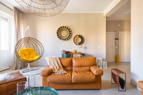 a living room with a brown couch and mirrors at Henry's House Parma in Parma