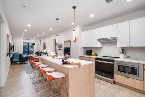 a kitchen with white cabinets and a counter with bar stools at Hyve-Retro Modern-Full Gym-Walk to Broadway in Nashville