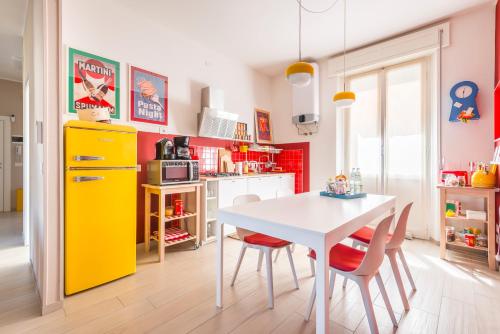 a kitchen with a white table and a yellow refrigerator at Henry's House Parma in Parma