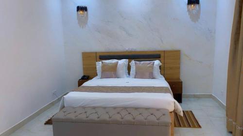 a bedroom with a large bed with a wooden headboard at Hôtel La Miséricorde in Douala