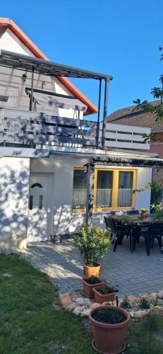 a house with a patio with a table in front of it at Igali Varázs Apartman 2 perc a fürdőtől in Igal