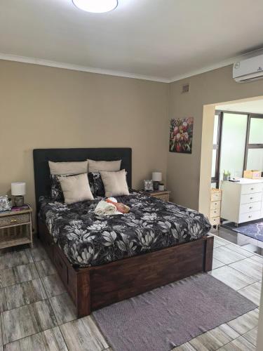 a bedroom with a large bed in a room at Protea House - self-catering house with a Pool in Durban