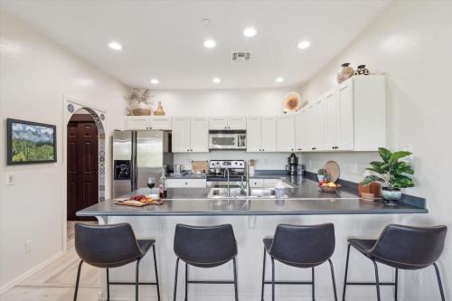 a kitchen with white cabinets and blue chairs at Panorama View - Mountain Views - Community Pool in Fountain Hills