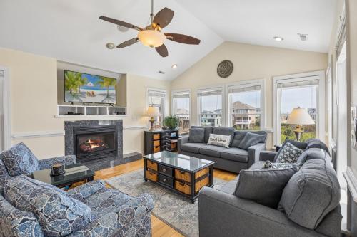 a living room with two couches and a fireplace at 6107 - No Wake Zone in Nags Head
