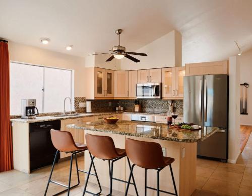 a kitchen with a large island with bar stools at Cactus Spur - Pool & Fire Pit - Mins to Old Town in Scottsdale
