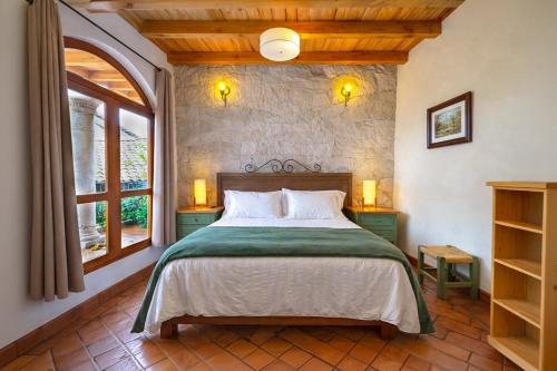 a bedroom with a bed and a large window at Hotel Boutique Siete Soles in Pátzcuaro