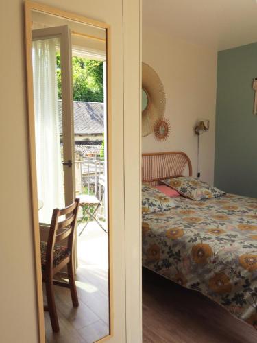 a bedroom with a bed and a table with a chair at Vagabondes - Chambres d'hôtes à Azay-Le-Rideau in Azay-le-Rideau