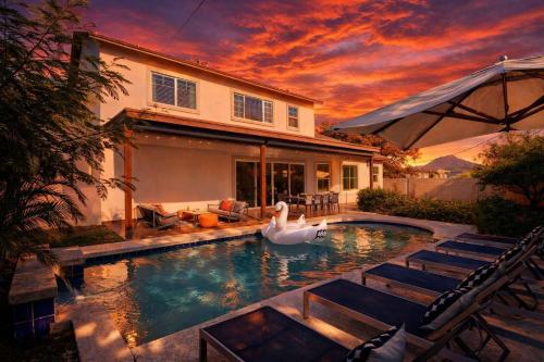 a swan swimming in a pool in front of a house at Contour - Sparkling Pool - Mins to Phoenician Golf in Phoenix