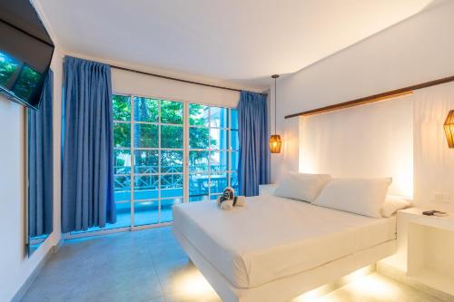 a bedroom with a large bed and a large window at Hotel Tropical Inn in Tierra Bomba