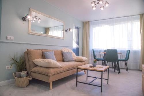 a living room with a couch and a table at Fountain View 2 bedroom Apartment in Naujoji Akmenė