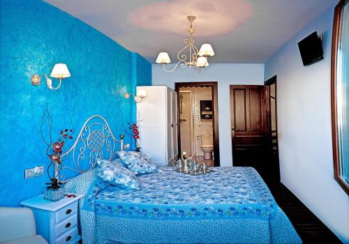 ein blaues Schlafzimmer mit einem Bett und einer blauen Wand in der Unterkunft Casa Rural Antonio in Vitigudino