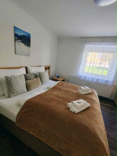 a bedroom with a large bed with two towels on it at Eisenerzer Apartmenthaus in Eisenerz
