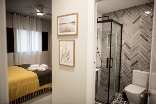 a bathroom with a bed and a shower and a toilet at ALMOHADES del JERTE in Galisteo