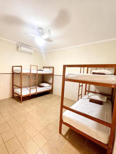 a room with three bunk beds and a ceiling at Hostel Diniz in Vitória