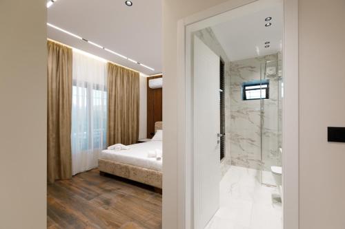 a bedroom with a bed and a walk in shower at Çifliku RSXH in Gjirokastër