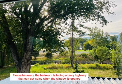 a tree with a sign that says please be aware the bedroom is facing a busy at Hikari-Okanagan Sunshine B&B in Kelowna