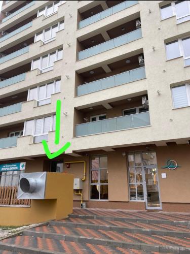 a building with a green arrow on the side of it at Apartament 2 camere Fial in Bacău