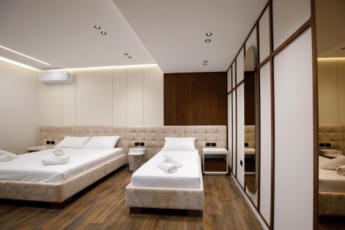 a hotel room with two beds and a mirror at Çifliku RSXH in Gjirokastër