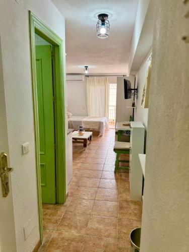 a living room with a green door and a kitchen at Luis Vives in Benalmádena