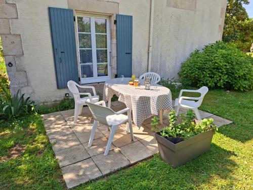 a table and chairs in the yard of a house at La Glycine, Maison au calme avec jardin, Fibre Wi-Fi, 20 min des plages, Parking privé in Luçon