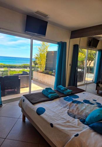 a bedroom with a large bed and a large window at Villa Perle De La Mer in Saint-Aygulf