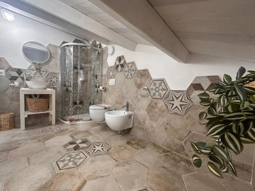a bathroom with two toilets and a sink and a mirror at Godano Rooms in Drapia
