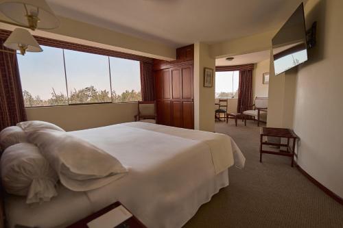 a hotel room with a bed and a large window at El Cabildo Hotel in Arequipa