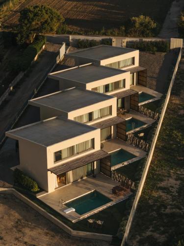 an aerial view of a building with a swimming pool at springs suites no4 in Kato Alepochori