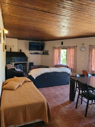 a bedroom with a bed and a table in a room at Departamento Castello in El Bolsón